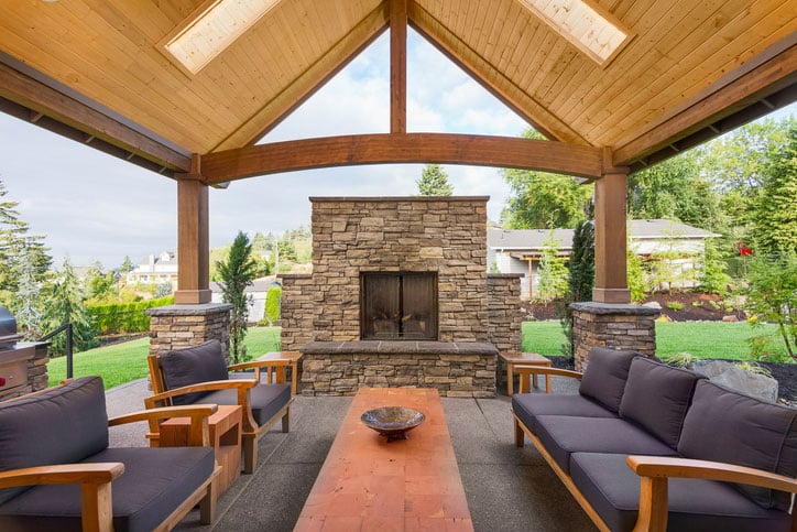 Covered patio with chairs and fireplace